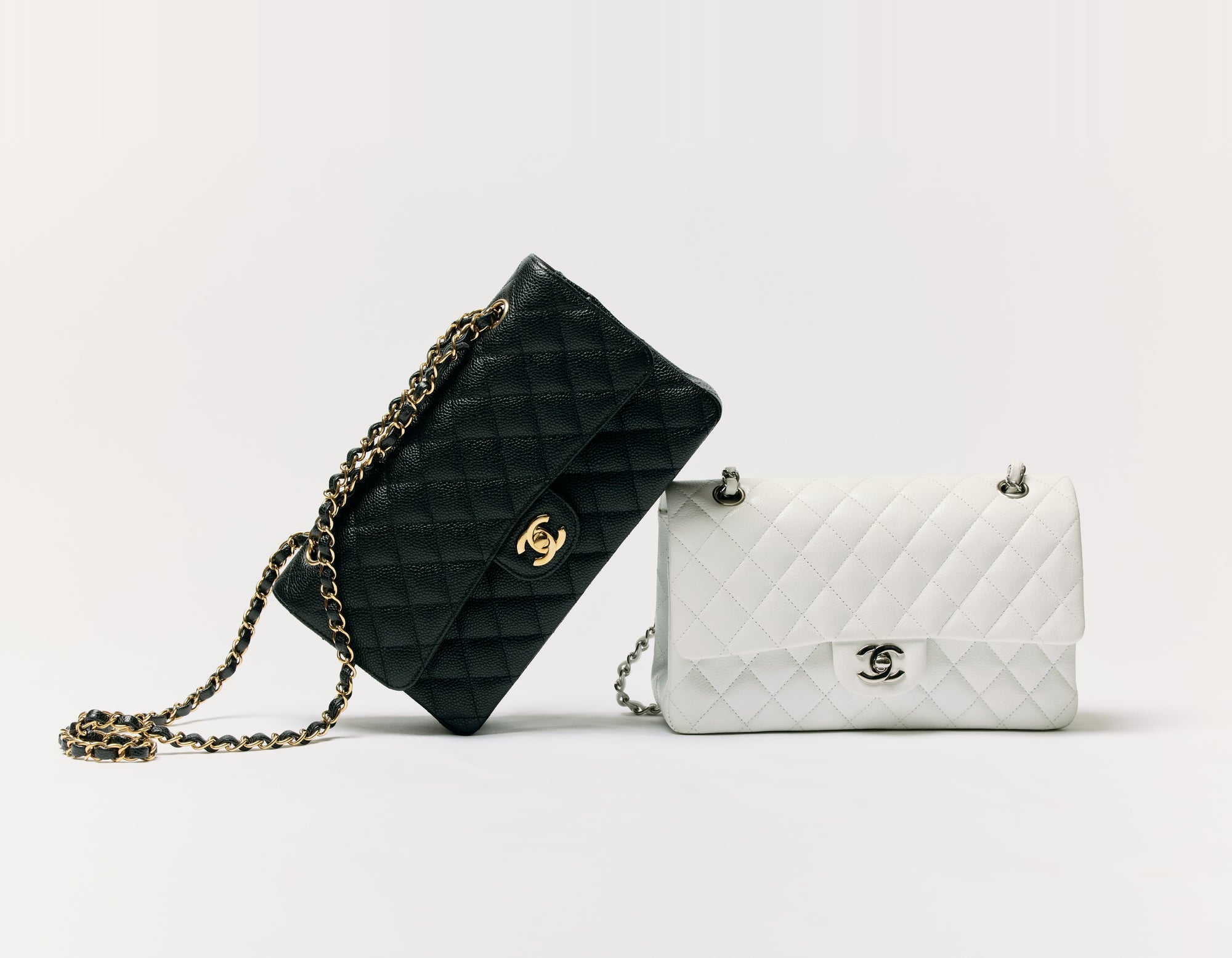 Black and white quilted Chanel flap bags on a pale studio backdrop