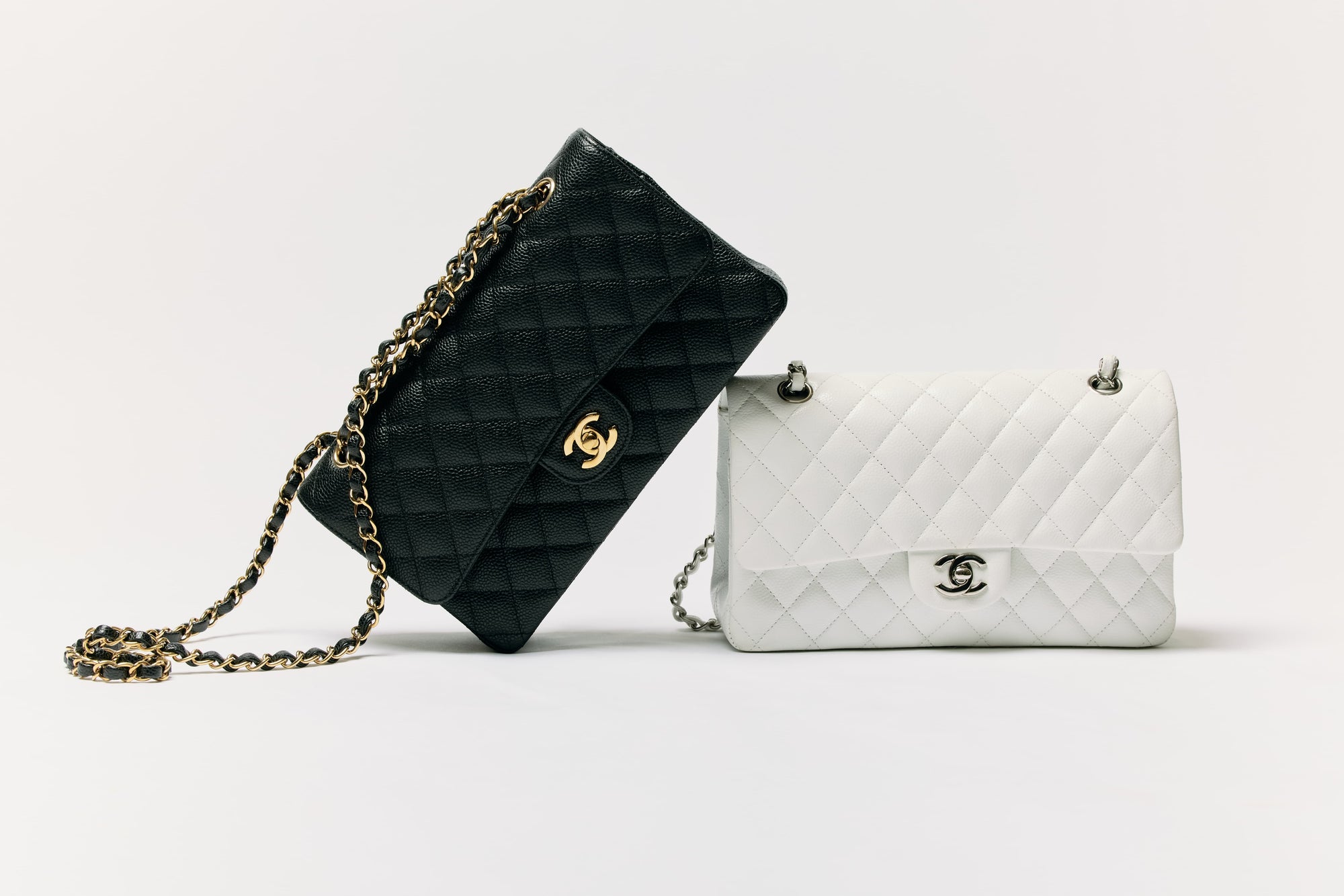 Black and white quilted Chanel flap bags on a pale studio backdrop