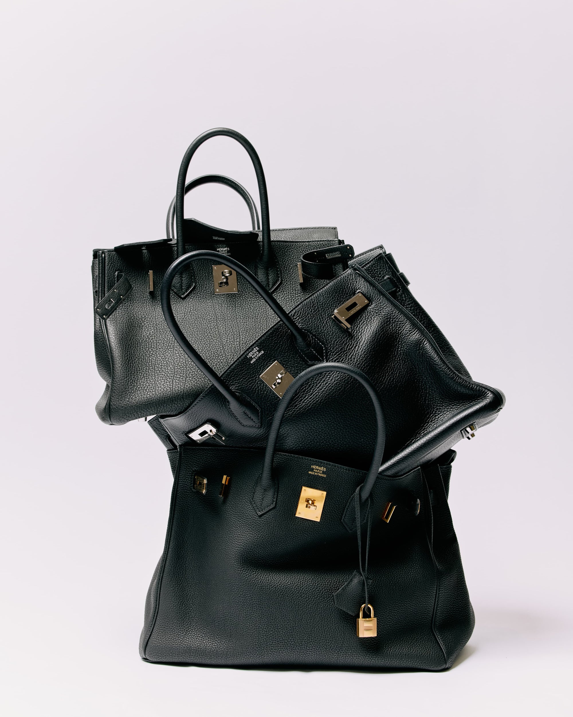 Stack of designer handbags arranged editorially